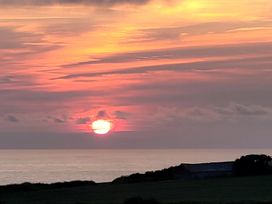 A sunset over the ocean with clouds at Badgers Sett in Stibb near Kilkhampton
