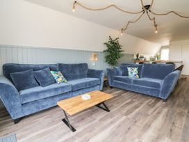 A living room with two blue sofas and a wooden coffee table at La Bella Vista in Kilkhampton