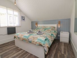 A bedroom with a bed a bedside table and window blinds at La Bella Vista in Kilkhampton
