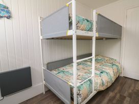 A bedroom with a white bunk bed and patterned bedding at La Bella Vista in Kilkhampton