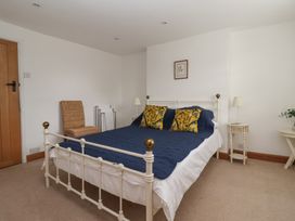 A bedroom with a bed and a bedside table at Pear Tree Cottage in Great Ouseburn