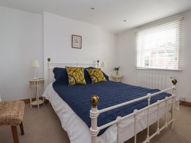 A bedroom with a bed and side tables at Pear Tree Cottage in Great Ouseburn