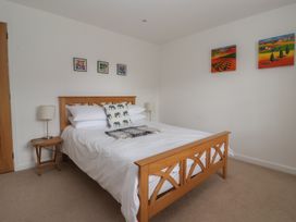 A bedroom with a bed and wall art at Pear Tree Cottage in Great Ouseburn