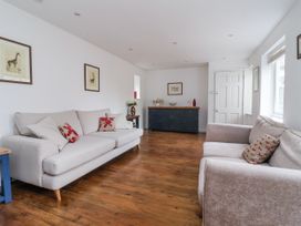 A living room with two sofas and a cabinet at Pear Tree Cottage Great Ouseburn