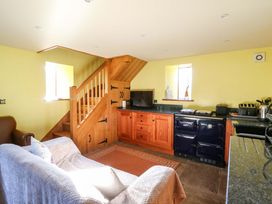 A kitchen with a sofa and staircase at Maggie's Barn Brecon