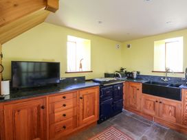 A kitchen with cabinetry and appliances at Maggie's Barn in Brecon