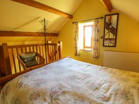 A bedroom with a bed and a window at Maggie's Barn in Brecon