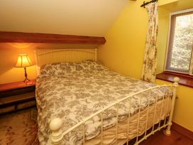 A bedroom with a bed and lamp at Maggie's Barn in Brecon