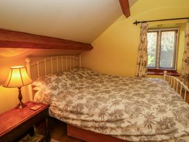 A bedroom with a bed and lamp at Maggie's Barn in Brecon