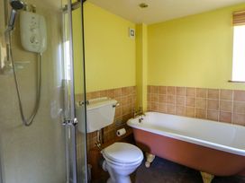 A bathroom with a shower, toilet, and bathtub at Maggie's Barn in Brecon