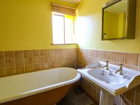 A bathroom with a bath tub and sink at Maggie's Barn Brecon