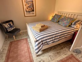A bedroom with a bed and armchair at The Packing House in Rosudgeon