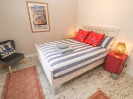 A bedroom with a bed and wall art at The Packing House in Rosudgeon