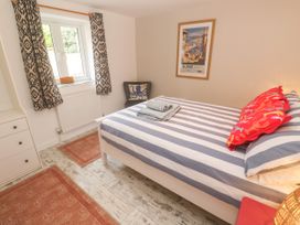 A bedroom with a bed and window at The Packing House in Rosudgeon
