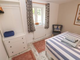 A bedroom with a bed and wardrobe at The Packing House in Rosudgeon