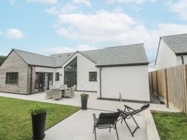 An outdoor area with a house, dining set and planters at Kerrek Lodge Mylor Bridge