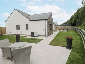 An outdoor area with a house and patio furniture at Kerrek Lodge Mylor Bridge