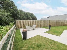 A garden with a table and chairs and planters at Kerrek Lodge Mylor Bridge