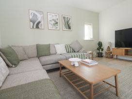 A living room with a sofa and television at Kerrek Lodge in Mylor Bridge