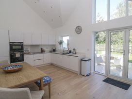A kitchen with a dining table and appliances at Kerrek Lodge in Mylor Bridge