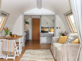 A living room with a table and couch at Under Oak Pod in Totnes