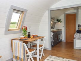 A kitchen with a dining table and chairs at Under Oak Pod in Totnes
