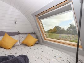 A bedroom with a bed and window at Under Oak Pod in Totnes