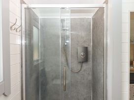 A shower enclosure with glass doors at Under Oak Pod in Totnes