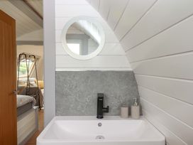 A bathroom with a sink and mirror at Under Oak Pod in Totnes