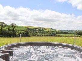A hot tub with a view of hills and fields at Under Oak Pod in Totnes