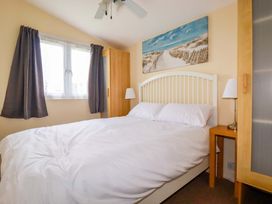 A bedroom with a bed and wardrobe at H2 Atlantic Bay Holiday Park Padstow