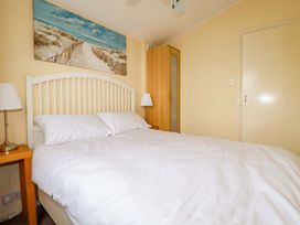 A bedroom with a bed and lamp at H2 Atlantic Bay Holiday Park in Padstow