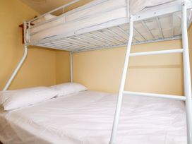 A bunk bed with a lower double mattress and pillows at H2 Atlantic Bay Holiday Park in Padstow