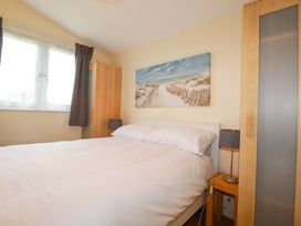 A bedroom with a bed and wardrobe at 161 Atlantic Bay Holiday Park in Padstow