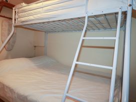A bunk bed with a ladder in a bedroom at 161 Atlantic Bay Holiday Park, Padstow