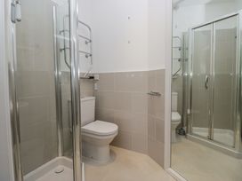 A bathroom with a toilet a glass shower enclosure and a towel rail at Sunnycroft in Keswick