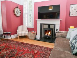 A living room with a fireplace and a TV at Sunnycroft in Keswick