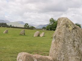A field with standing stones and mountains in the background at Sunnycroft in Keswick
