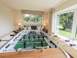 A foosball table with a sofa and window at Rowanhill in Kendal