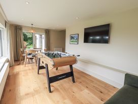 A game room with a foosball table and television at Rowanhill in Kendal