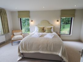 A bedroom with a bed and chairs at Rowanhill in Kendal