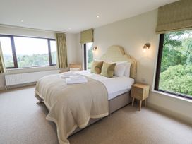 A bedroom with a bed and windows at Rowanhill in Kendal