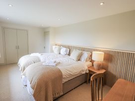 A bedroom with two beds and a table at Rowanhill in Kendal