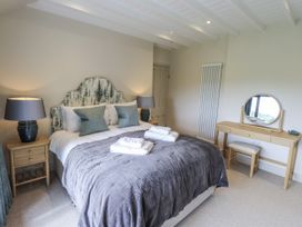 A bedroom with a bed and mirror at Rowanhill in Kendal
