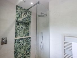 A shower with glass door and wall tiles at Rowanhill in Crook near Staveley