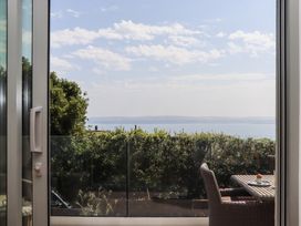 A view of the sea from a window with a table and chairs at Seacroft in Torquay