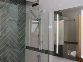 A bathroom with a shower and mirror at Seacroft in Torquay