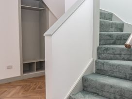A hallway with a staircase and cupboard at Seacroft in Torquay