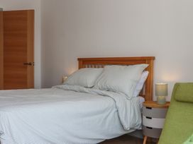 A bedroom with a bed, nightstand, and lamp at Seacroft in Torquay
