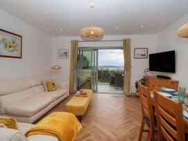 A living room with a sofa and dining area at Seacroft in Wellswood near Torquay